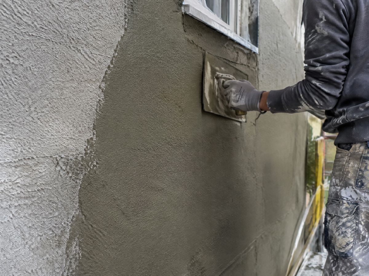 Gevel van een rijwoning met crepi en nieuwe ramen